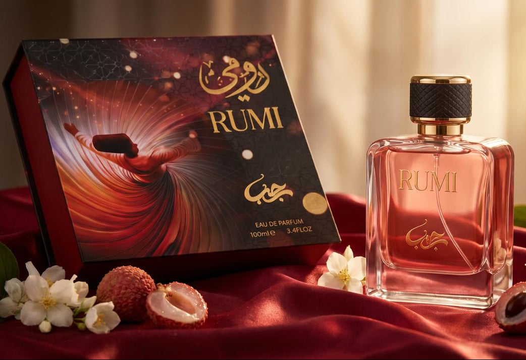 Rumi Eau de Parfum bottle and its illustrated box, styled on a red satin surface with lychee fruits and white flowers. The bottle contains pinkish-red liquid and has gold lettering, while the box features a dark, swirling abstract design with gold RUMI branding.